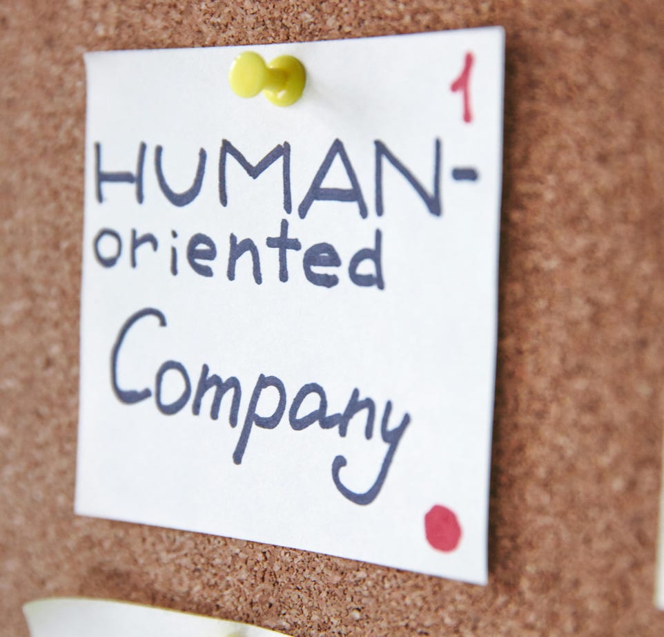 Handwritten notes on a corkboard illustrating a human-oriented company concept. Ideal for business innovation themes.
